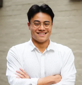 Headshot portrait of Anthony Lin with arms crossed smiling