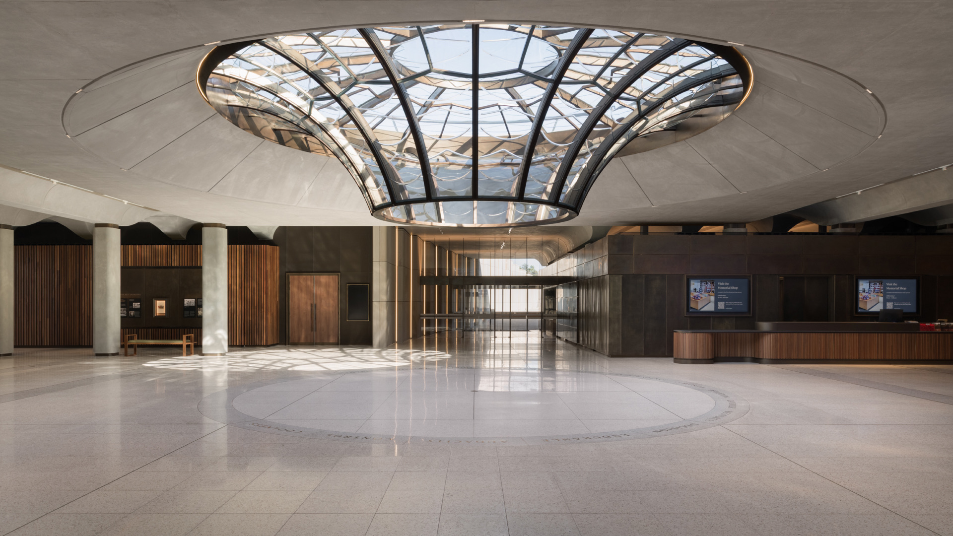 Grand circular lobby with a funnel-shaped glass oculus skylight and terrazzo floor